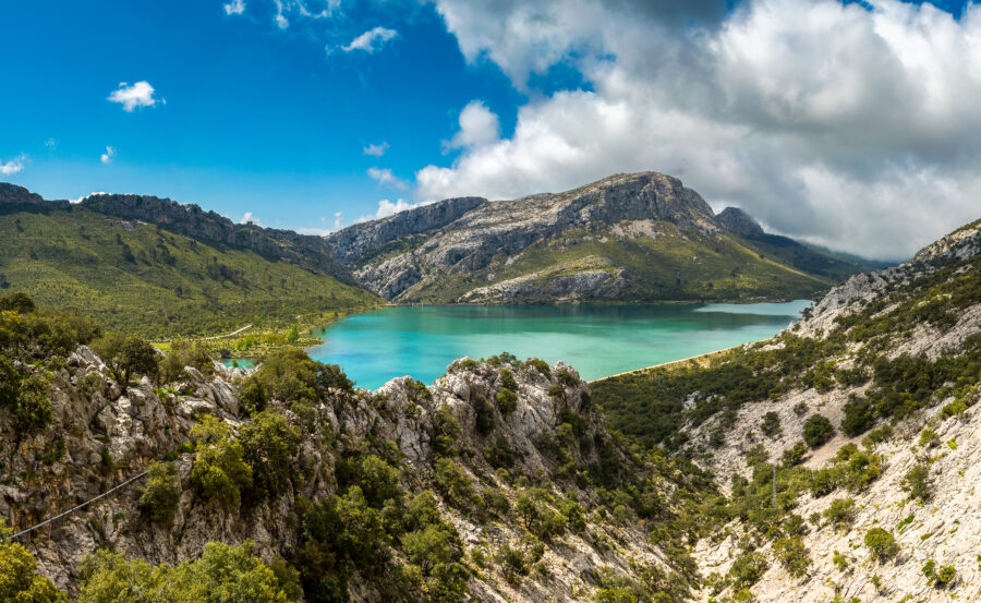 Aerial view of the Serra de Tramuntana mountains in Mallorca, showcasing rugged peaks and lush green valleys