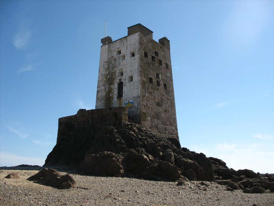 Seymour Tower stands on a sandy beach, surrounded by water and coastal scenery in Jersey.