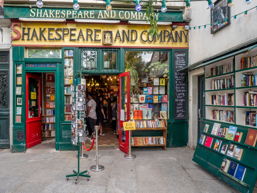 Entrance to Shakespeare and Company bookstore in Paris' Latin Quarter, featuring a charming facade and welcoming atmosphere /