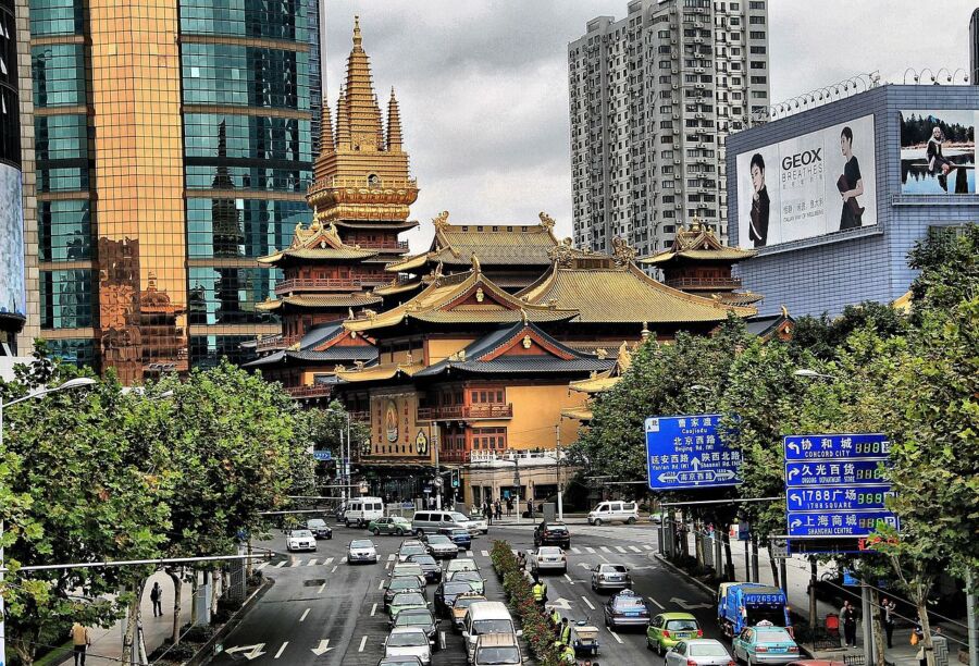 Contrasting Jing’an traditional temple and modern skyscrapers in a bustling urban environment.
