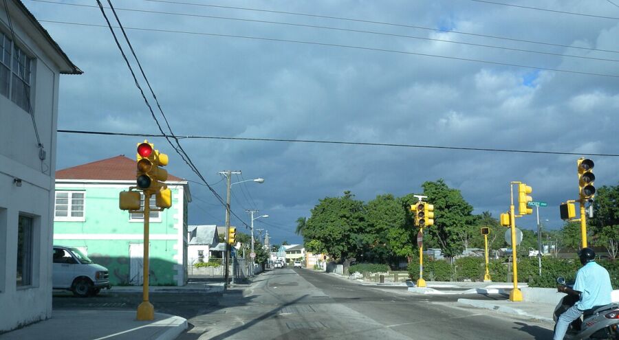 Shirley and Mackey Streets in Nassau, showcasing a motorcycle and a car on the side of the road.