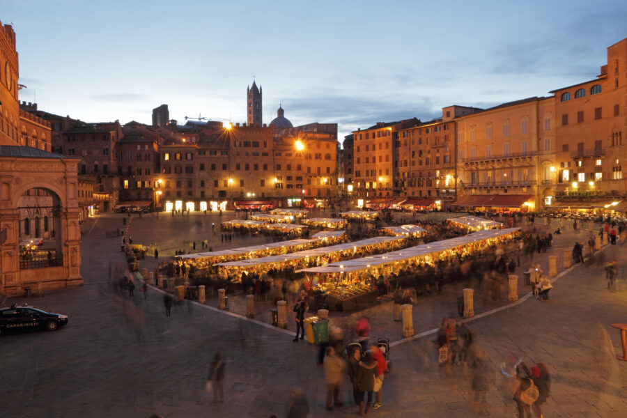 Traditional Mercato Grande in Siena, showcasing vibrant stalls filled with fresh produce and local goods in a bustling atmosphere