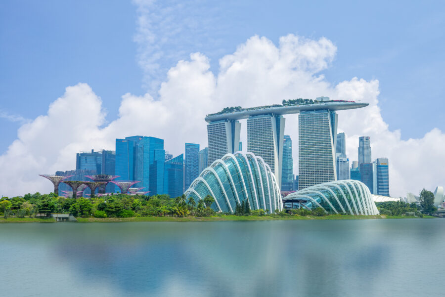 Skyline of Singapore featuring iconic buildings and the Marina Bay area under a clear blue sky
