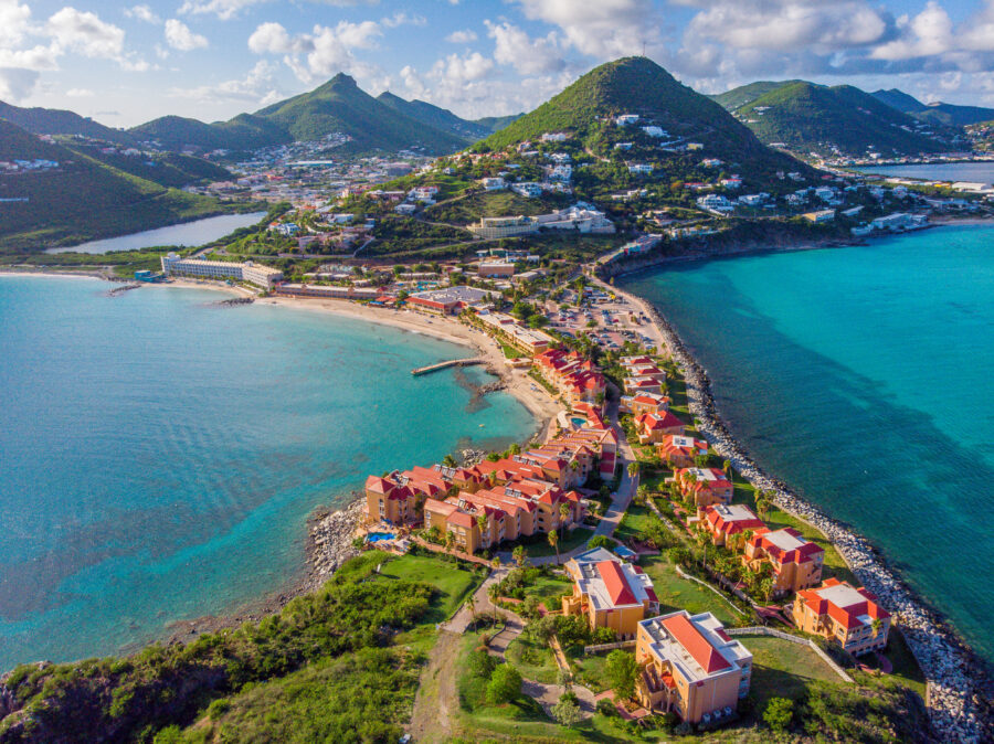 Aerial view of St. Maarten, showcasing its lush greenery, sandy beaches, and vibrant blue waters