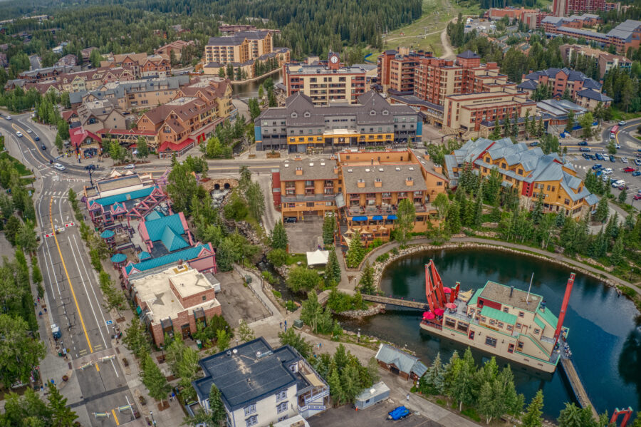 Aerial view of Breckenridge, Colorado, showcasing the ski resort town surrounded by snow-capped mountains and pine trees.