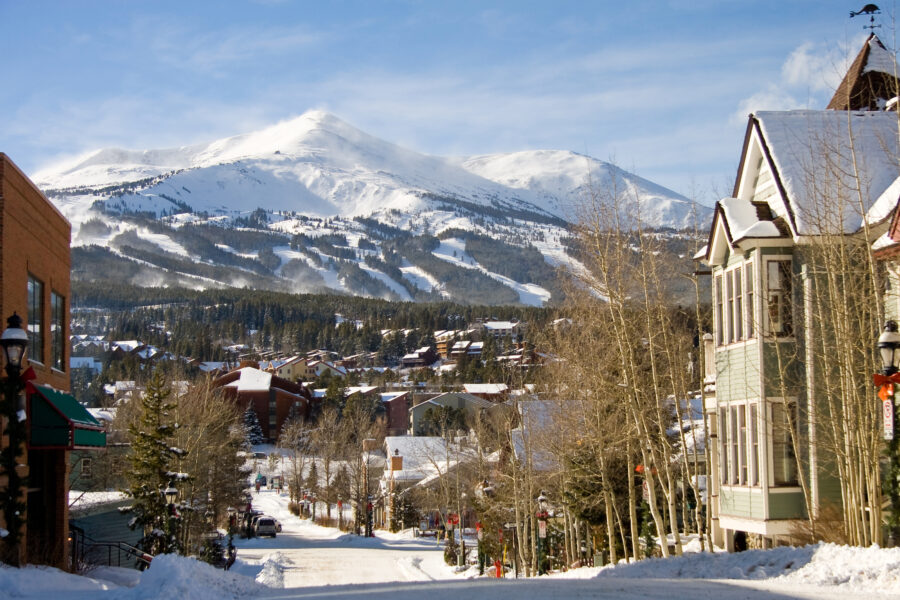 Snowy street scene in Breckenridge, Colorado, featuring Peak 8 in the background, capturing the essence of winter in Summit County