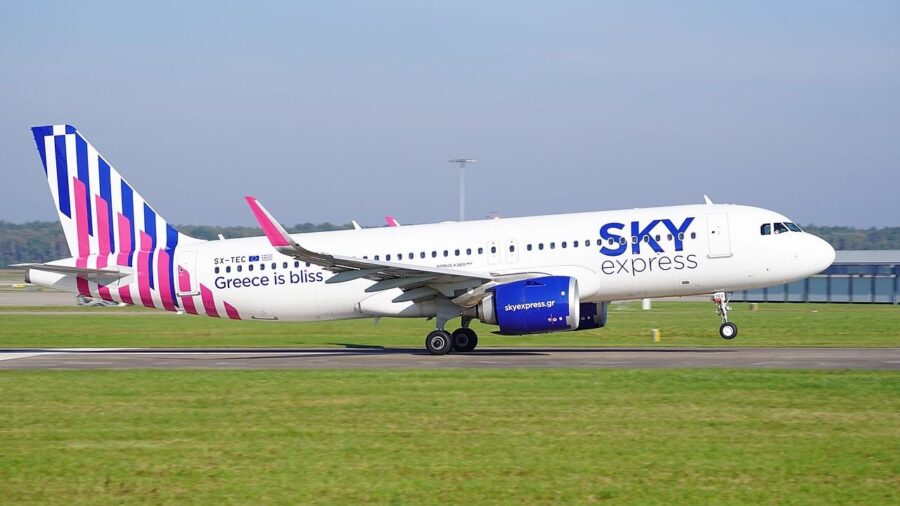 Sky Express Airbus A320 with vibrant livery and slogan Greece is bliss on runway.
