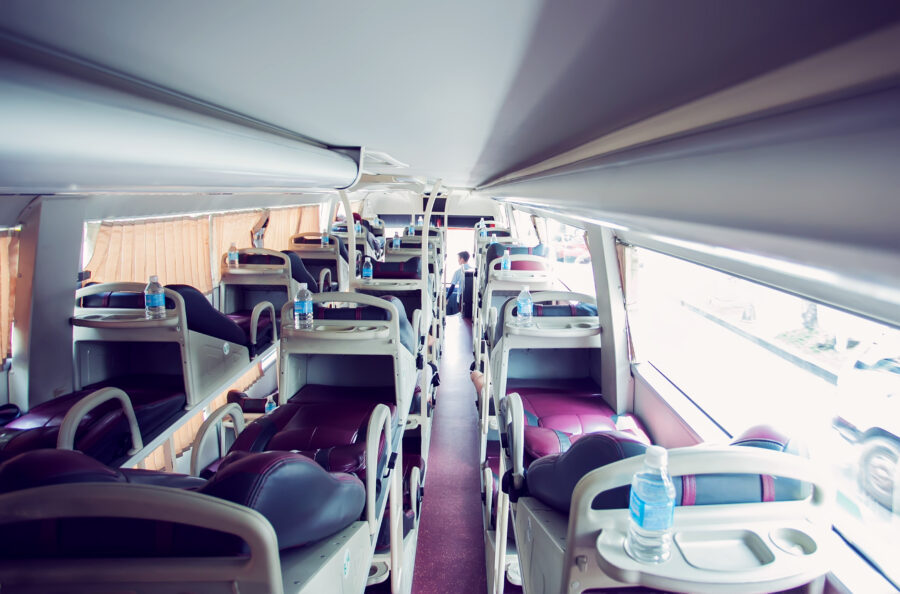Interior view of a sleeper bus featuring cozy sleeping pods