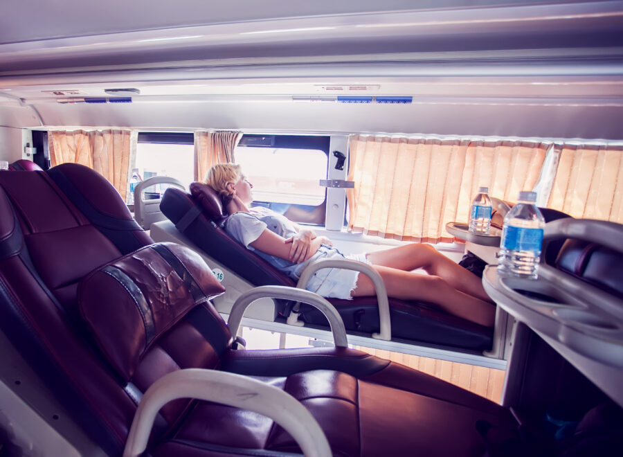 Interior view of a sleeper bus, featuring cozy bunks and seating for tourists and passengers on a long journey.