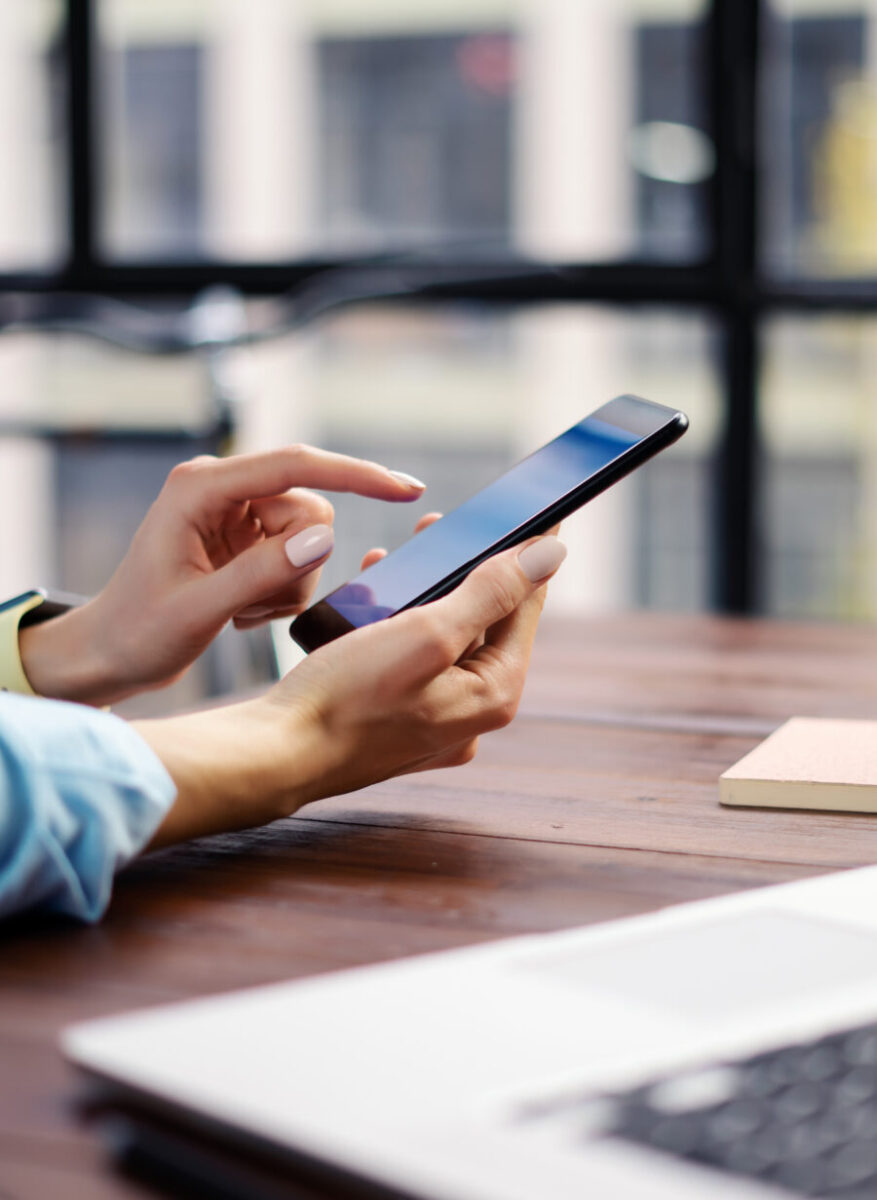 Woman pointing at smartphone screen while chatting on social networks and browsing the internet.