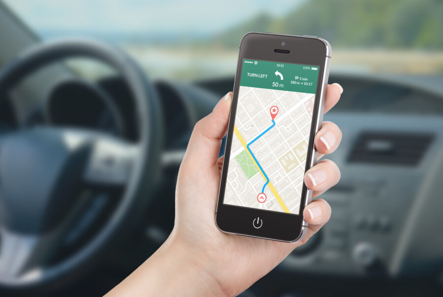 Smartphone navigation app displayed on a car's dashboard, showing a map and route directions.