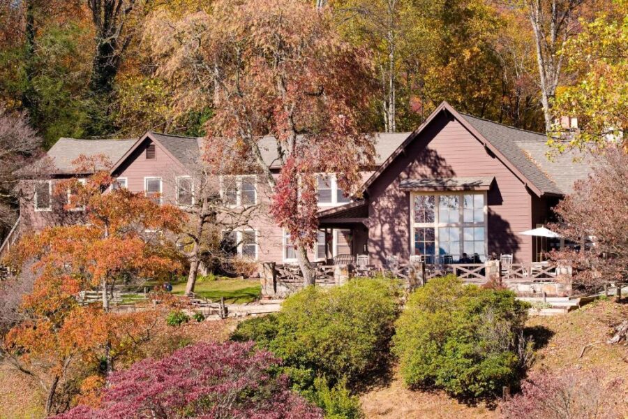 Snowbird Mountain Lodge in North Carolina, featuring a large house framed by vibrant autumn foliage.