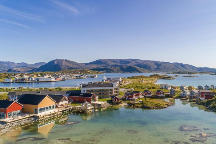 Scenic view of Lofoten village in Norway, featuring the Sommarøy Arctic Hotel amidst stunning natural landscapes.
