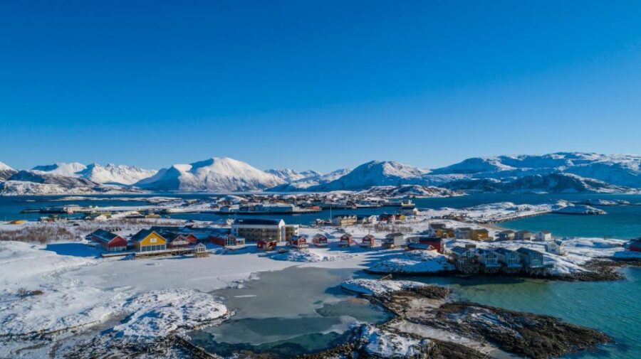 Scenic view of the Lofoten Islands in Norway, featuring rugged mountains and clear blue waters near Sommarøy Arctic Hotel.
