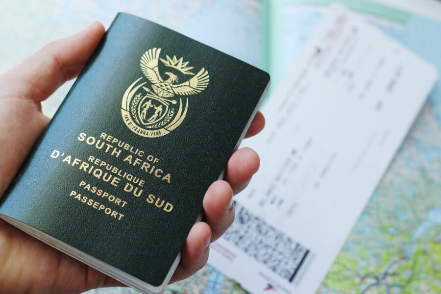 South African passport with emblem, travel documents, and map background suggests exploration and adventure.