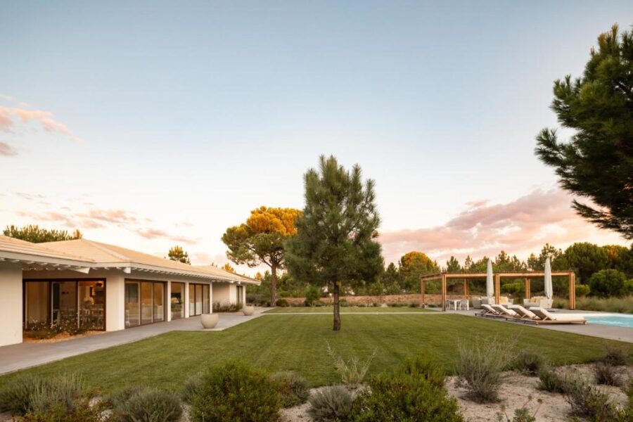 Modern home in Spatia Comporta, Portugal, featuring a pool and a well-maintained lawn.