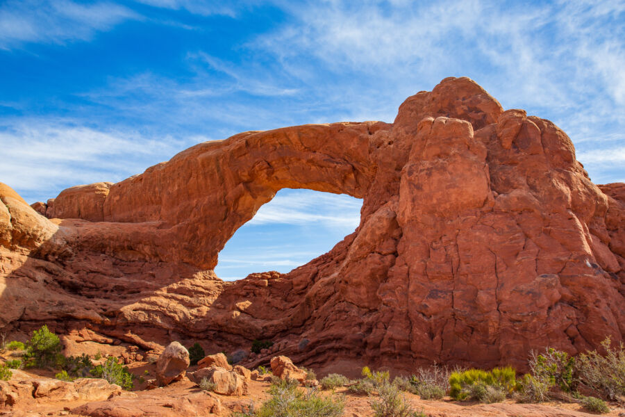 Panoramic view of Spectacle Arch, showcasing its unique shape against the stunning landscape of Arches National Park
