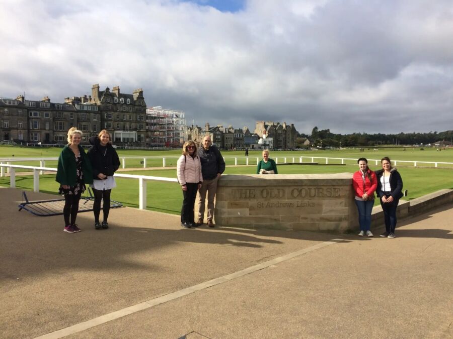 Visitors pose in front of a monument as part of the St. Andrews Town Guided Walking Tour.