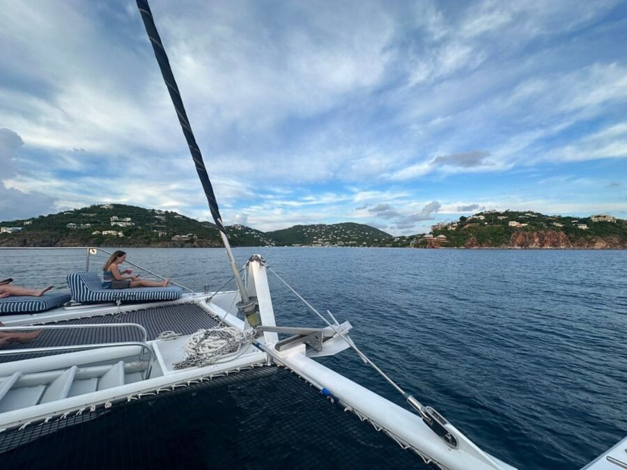 People relax on a boat deck during the St. John Days End Sunset Sail, enjoying the serene sunset views.