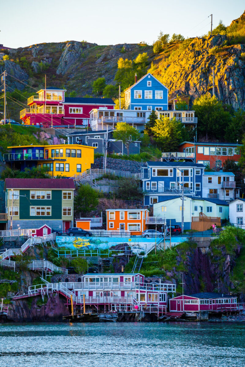 Colorful houses line the hillside of a mountain in St. John, Newfoundland, Canada, showcasing vibrant architecture.