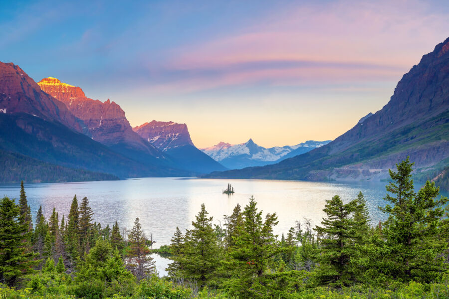 Panoramic view of sunrise illuminating St. Mary Lake in Glacier National Park, Montana, with mountains in the background