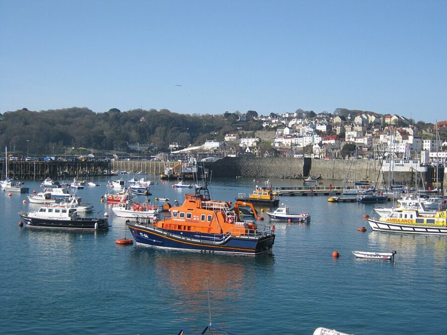 Several boats bobbing in the water at St Peter Port, Guernsey, showcasing the coastal scenery of the United Kingdom.

