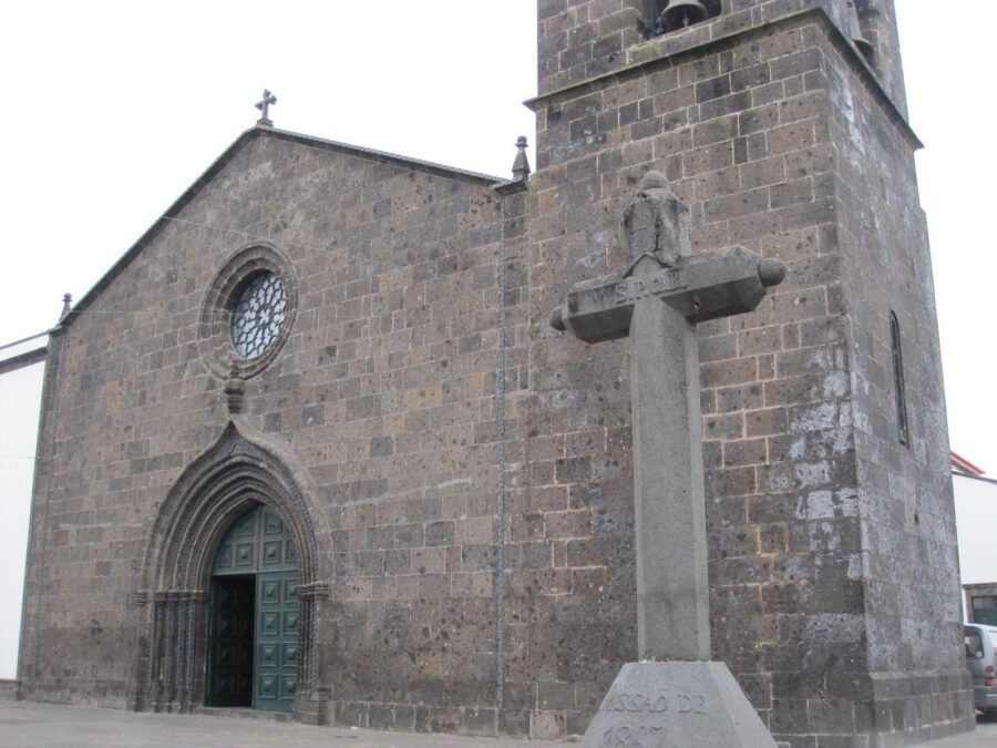 Historic stone church with rose window and bell tower, Igreja de São Miguel.