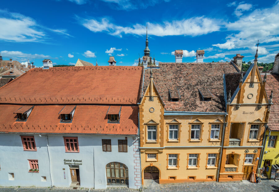 Aerial view of townhouses on Scolii Street in the historic Old Town of Sighisoara, Romania, showcasing vibrant architecture