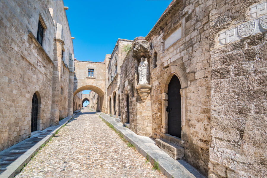 Scenic Street of the Knights of Rhodes lined with historic castle architecture and a prominent wall in Rhodes, Greece