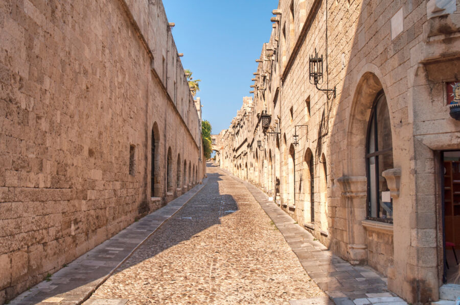 Historic Street of the Knights of Rhodes featuring old castle architecture and a large stone wall, showcasing the Knights of Rhodes' heritage