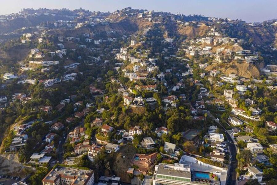Aerial view of West Hollywood hillside homes, lush greenery, and winding roads.