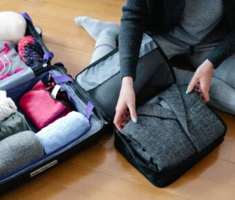 Traveler packing a suitcase with neatly organized clothes and accessories for a versatile trip.