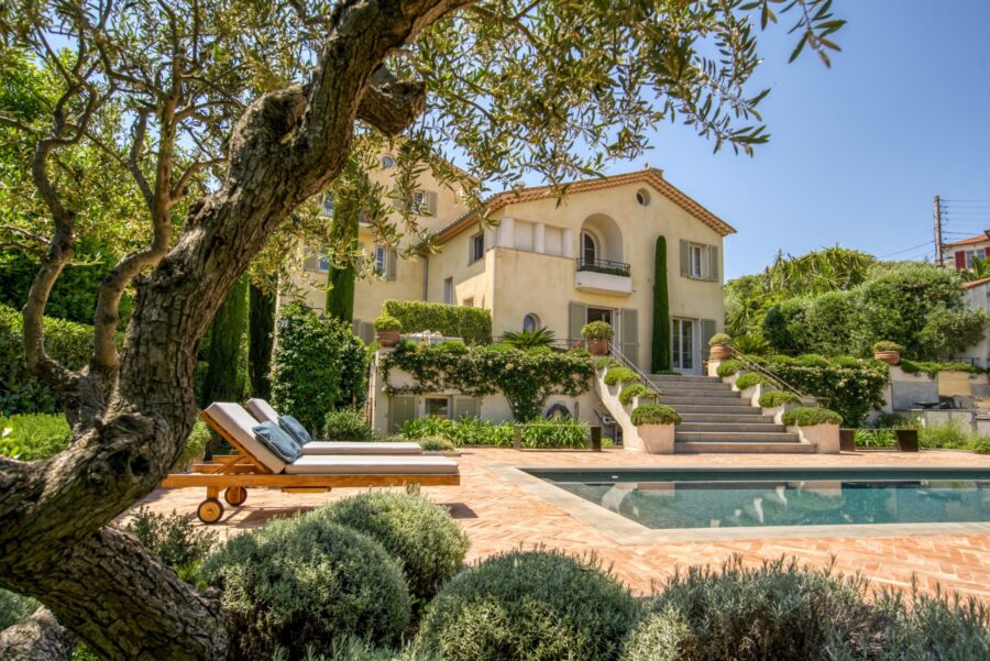 Antibes Mediterranean villa with pool, terrace lounge chairs, and manicured garden.