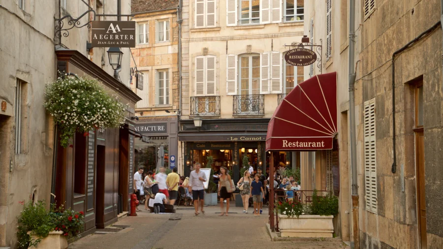 Beaune cobbled street with cafe-restaurant, historic French town evening scene.