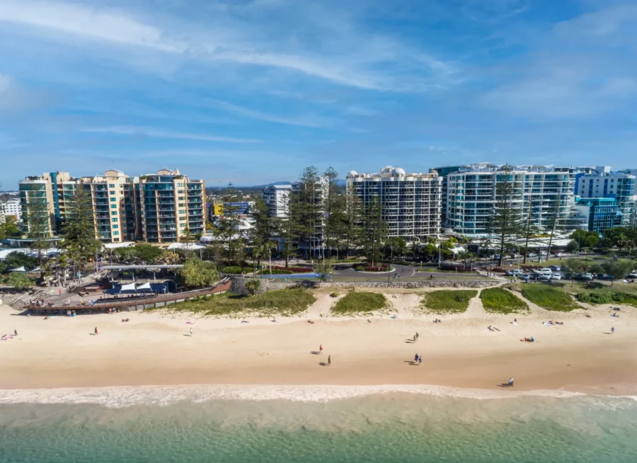 Aerial view of Mooloolaba beach, sandy shoreline, oceanfront apartments, sunny Queensland coastal resort.