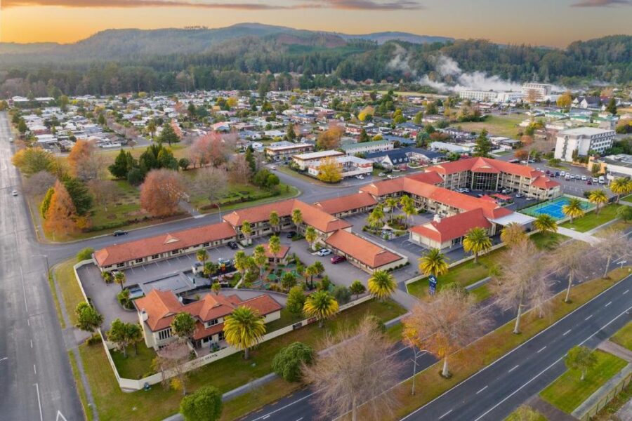 Aerial sunset view of Regal Palms resort, suburban town, autumn trees, hills and distant mountains.