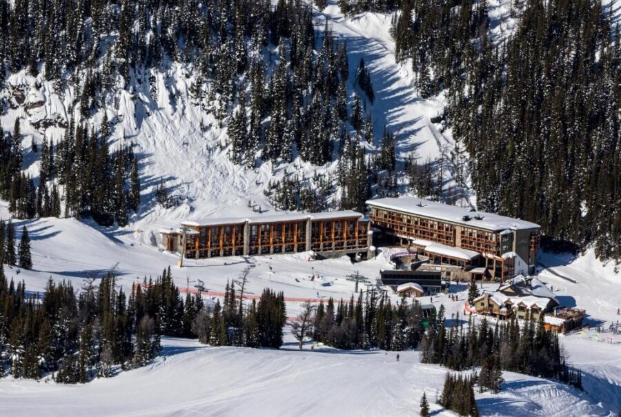 Aerial view of Sunshine Mountain Lodge in Banff, Canada, showcasing a ski resort surrounded by snow-covered trees.