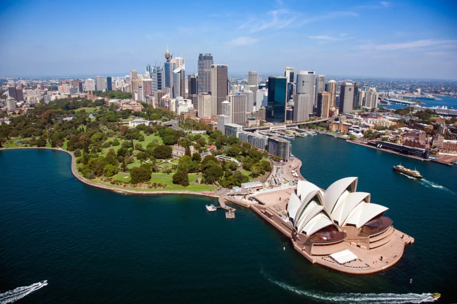 Aerial view of Sydney Opera House, skyline, harbor, and greenery in Australia.