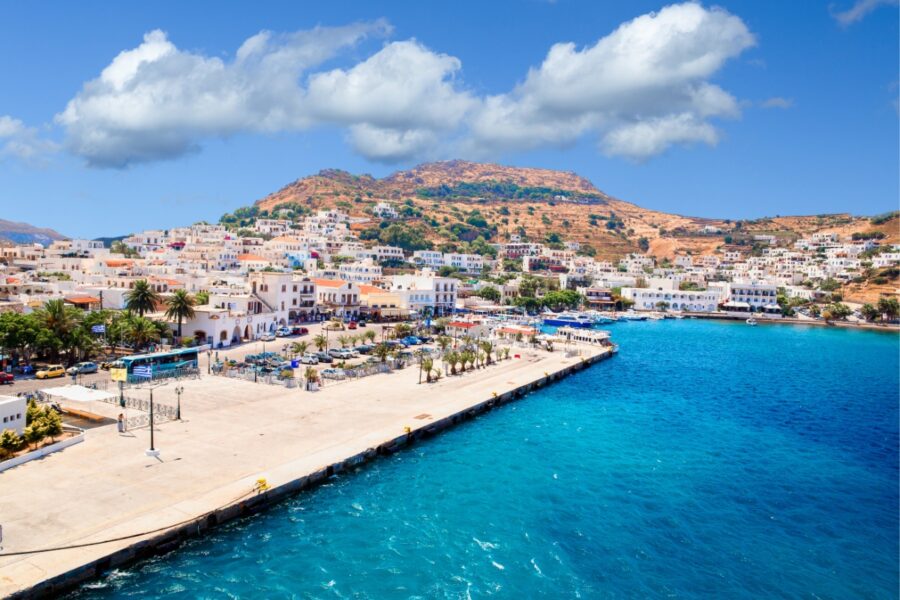Summer view of Hermoupoli city on Syros Island, Greece, showcasing vibrant buildings and clear blue skies.
