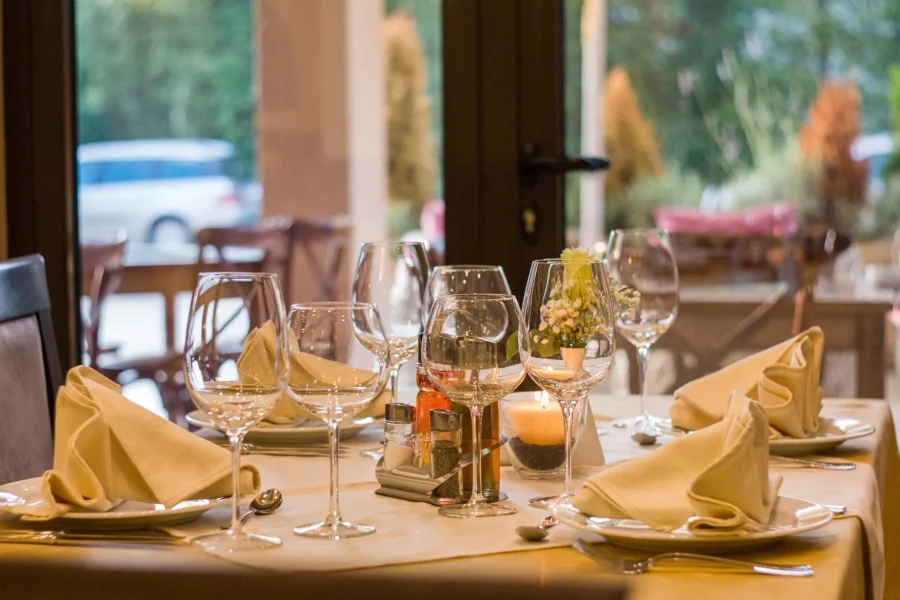 Intimate restaurant table setting with wine glasses, cloth napkins, candle, and floral centerpiece in Nafplio.