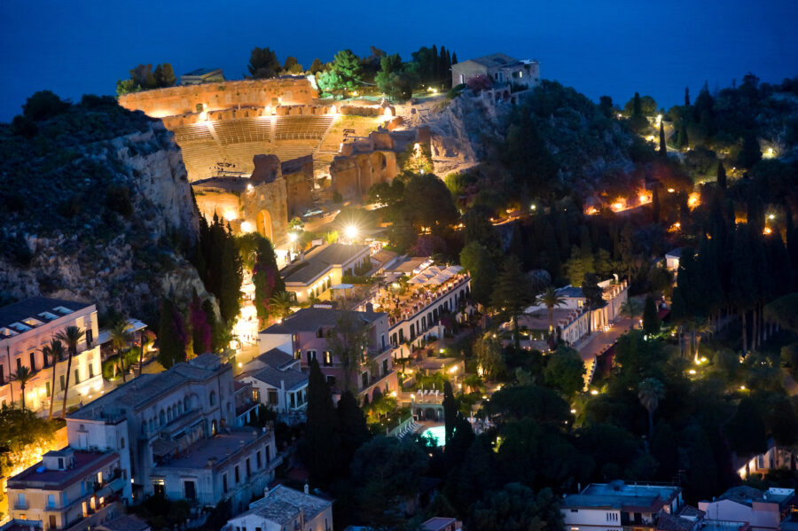 Night view of Taormina, Italy, showcasing illuminated buildings