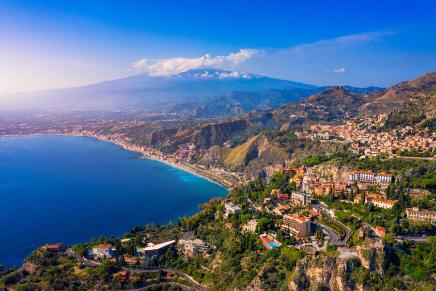 Taormina cityscape in Sicily, with the majestic Mount Etna rising in the background, highlighting the region's beauty