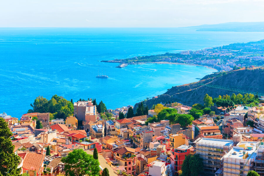 Panoramic view of Taormina cityscape overlooking the Mediterranean Sea in Sicily, showcasing historic architecture and coastline