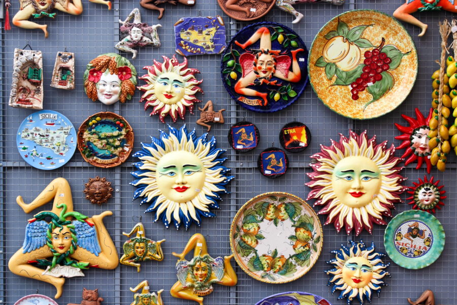 Display of colorful Taormina souvenirs, including ceramics, postcards, and local crafts, showcasing the region's culture