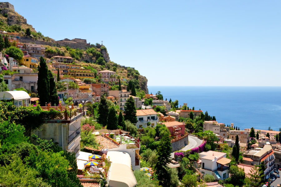 Panoramic view of Taormina, Sicily, from Castelmola, showcasing the coastline and historic architecture