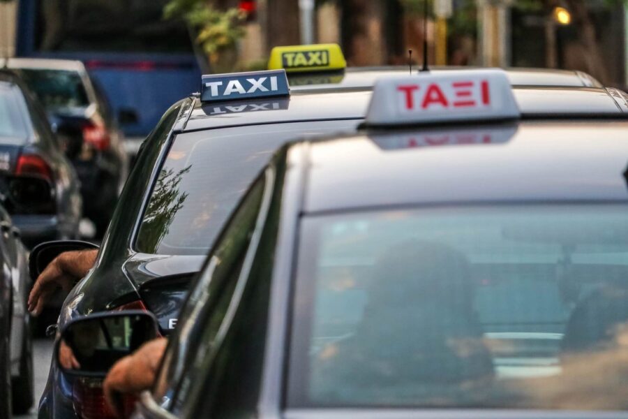 Taxis on busy urban street with bilingual signs in a multicultural city.