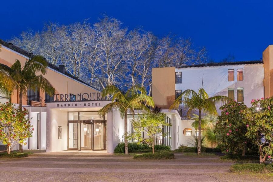 The illuminated front entrance of Terra Nostra Garden Hotel in Portugal at night, showcasing its welcoming atmosphere.