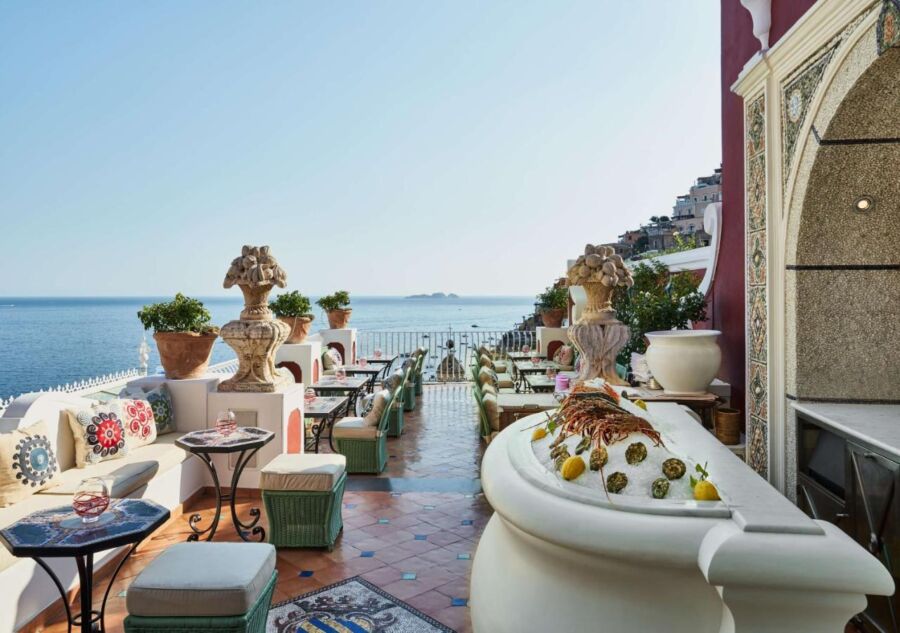 Luxurious seaside dining terrace with elegant furnishings and stunning ocean view.