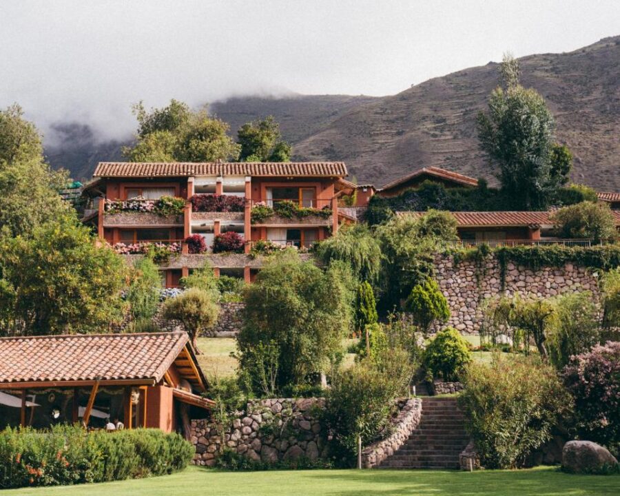 Terraced mountain resort with flowered balconies, stone steps, and lush gardens in a tranquil valley.