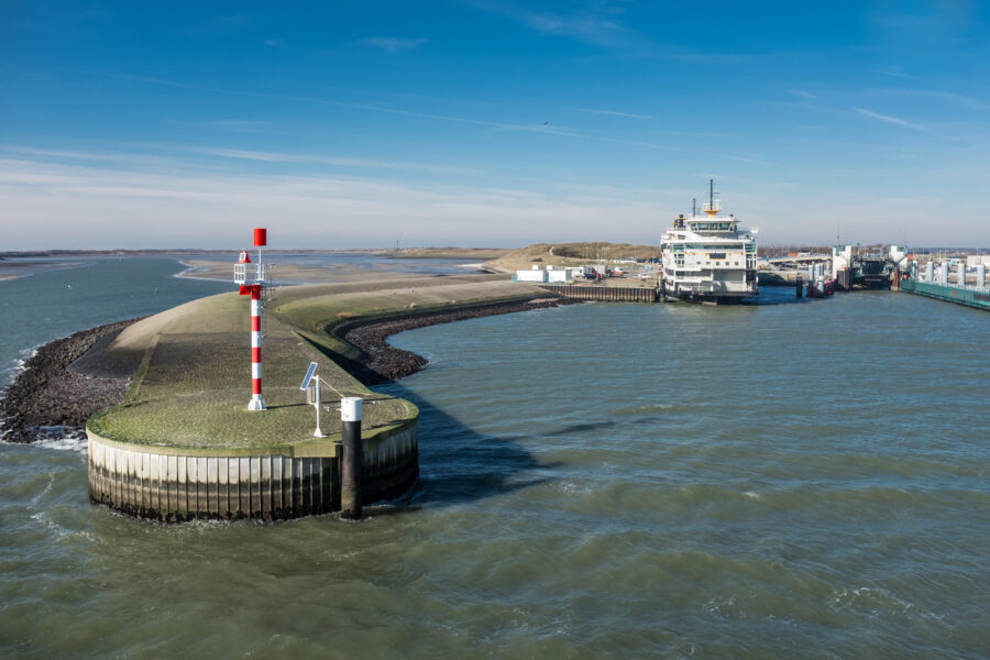 Ferry terminal at Texel Island, Netherlands, bustling with tourists and boats ready to depart for the mainland.